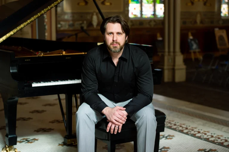 Andrzej Kozlowski sits at his piano. Photo Credit: Annie Farber.