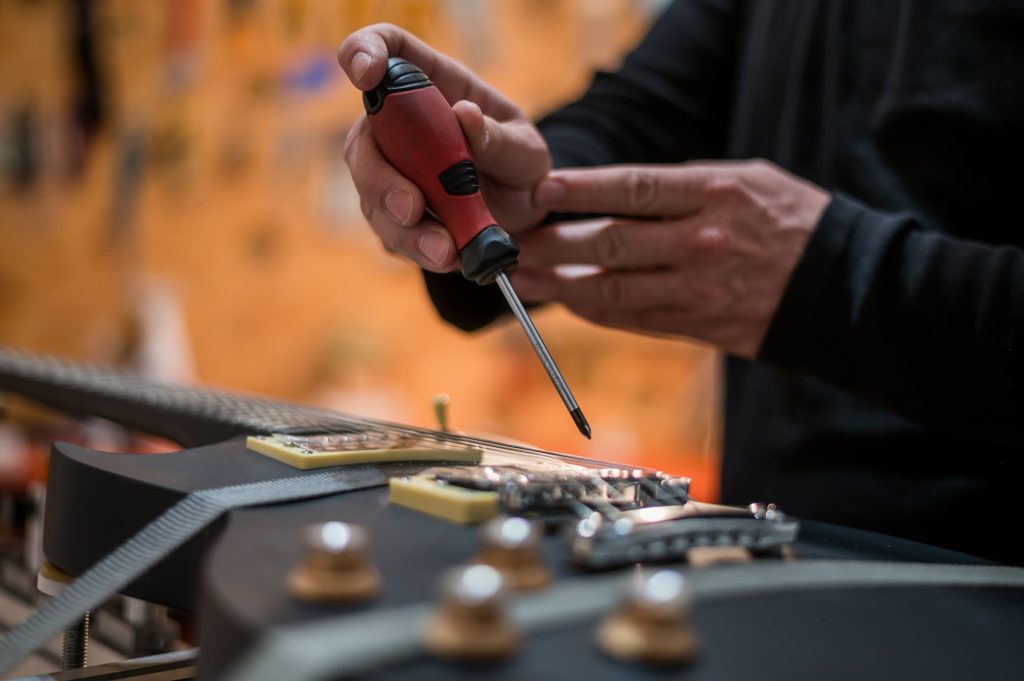 guitarrepair Guitar in repair service shop with a hands of a guitar luthier