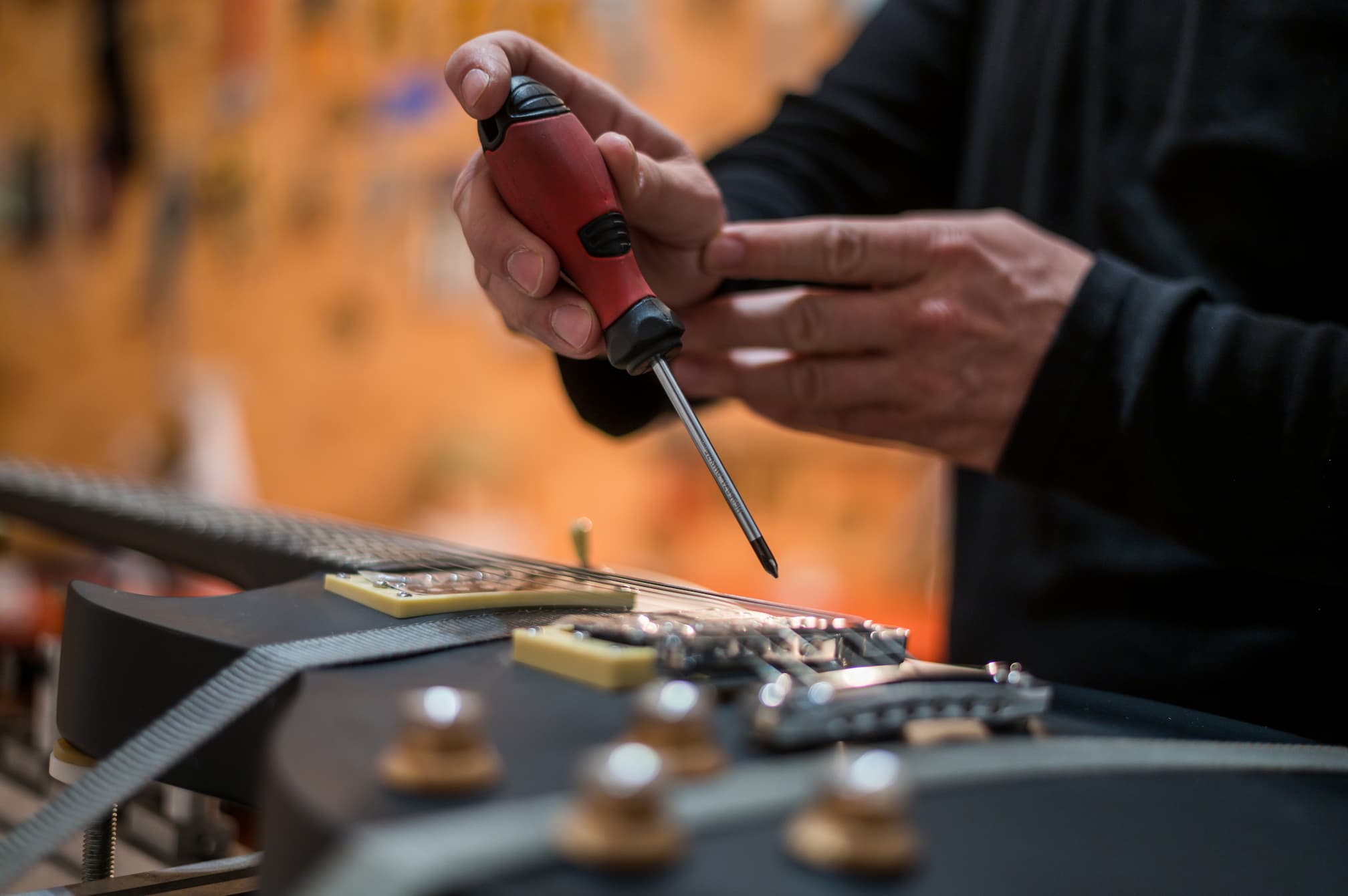 Guitar in repair service shop with a hands of a guitar luthier